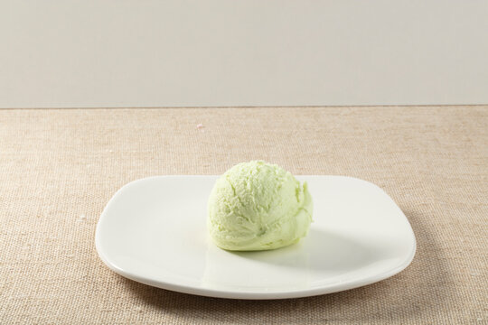 Helado de pistacho sobre plato y mantel. Pistachio ice cream on a plate and tablecloth.