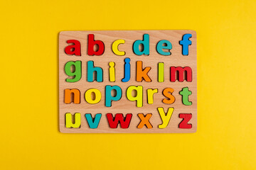 Letters of the English alphabet on a yellow background top view.