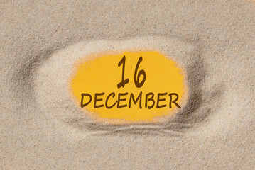 December 16. 16th day of the month, calendar date. Hole in sand. Yellow background is visible through hole. Winter month, day of the year concept