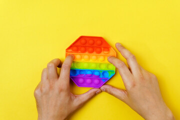 Colorful anti stress touch pop it toy. On a yellow background. Top view