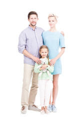 Fototapeta na wymiar Vertical full length isolated shot of modern father, mother and little daughter wearing casual clothes standing together looking at camera