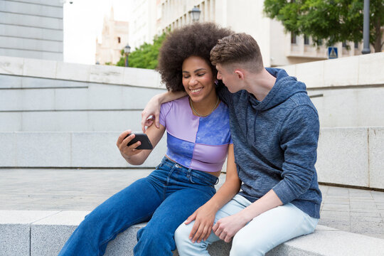 diverse couple using mobile phone
