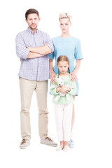 Fototapeta na wymiar Vertical full length isolated shot of family with one child standing together looking at camera with serious facial expressions, white background