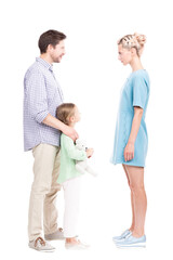 Vertical full length shot of little girl standing with her father and mother watching them quarrelling about something, white background