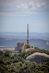 Obraz premium Cell tower (Base station or base radio station) on the top of Montserrat, Mountain, Catalonia, Spain. View from above. Aerial view.