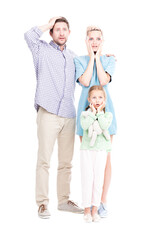 Vertical full length shot of modern man and woman standing with their little daughter astonished at something, white background