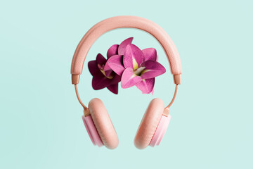 Pink headphones with tropical flowers on turquoise background, 3D rendering