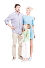 Vertical full length shot of little Caucasian girl showing something to her parents pointing finger at camera, white background