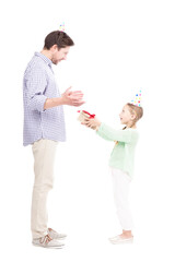 Vertical full length side view shot of cute Caucasian daughter giving gift box to her father, white background