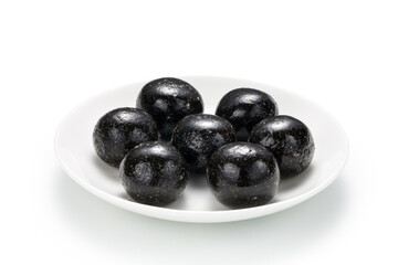 Black sesame ball in a plate isolated on white background. Chinese snack.