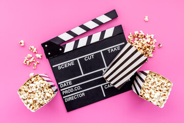 Layout of film reel with popcorn and clapperboard. Cinema concept