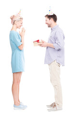 Vertical full length shot of beautiful young woman giving gift box to her husband for birthday, white background