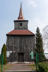 Fototapeta na wymiar Wooden tower of the Church St. John the Baptist (Kościół św. Jana Chrzciciela), 18th century. Sielsko (village in Lobez County), Poland.