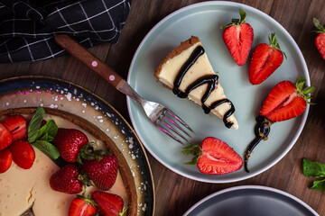 cream cheesecake with strawberries, mint and chocolate. portions of dessert on a dark background 