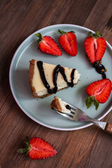 cream cheesecake with strawberries, mint and chocolate. portions of dessert on a dark background 