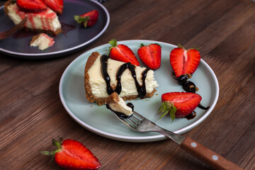 cream cheesecake with strawberries, mint and chocolate. portions of dessert on a dark background 