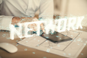 Double exposure of man's hand holding and using a digital device and data theme hologram drawing. Technology concept.