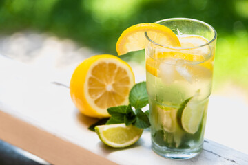 Cool freshly made lemonade and fruits. Lemon, lime and mint lemonade with ice.