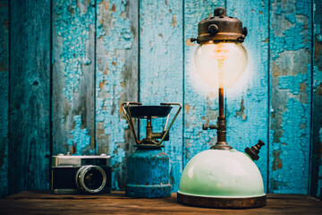Antique kerosene lamps and old camera. on a wooden table on a green wooden background.vintage style.