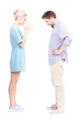 Vertical full length side view studio shot of angry young adult woman quarrelling with her husband, white background