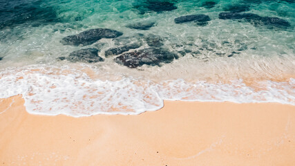 Sand and sea. Top view of beautiful tropical beach. Bright Sand beach with clear sea water surface with rocks. Sandy coastline and sea waves surface at Koh Kood, Trat, Thailand