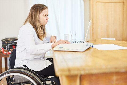 Business Frau im Rollstuhl arbeitet am Computer im Home Office