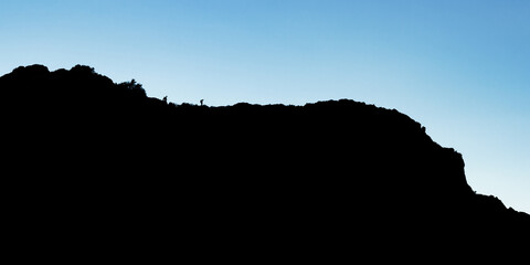 silhouette of hikers on a mountain ridge