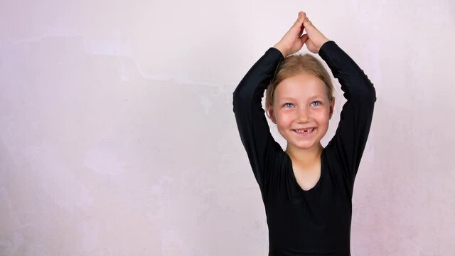 Little girl on yoga class in Siddhasana lotus pose on mat smiling. Online stretching practicing for children, flexibility health care active lifestyle sport. Wellness training at home 4K. New normal