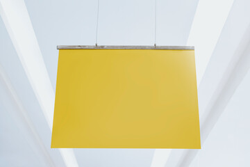 Yellow poster sign hanging from a ceiling