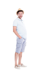 Vertical full length studio portrait of handsome bearded Caucasian man wearing summer outfit with hat standing relaxed, white background