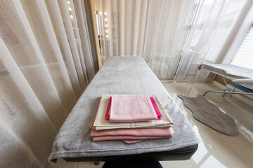 interior of the spa salon a couch with a clean one and towels behind a screen in a separate office