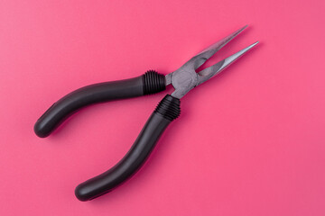 Isolated metal pliers with plastic black handles