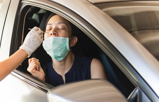 Medical Worker Taking Nasal Swab From Woman In Car To Test For Covid-19 Infection.