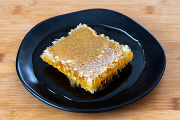 Organic honeycomb on wooden background. honey on the plate