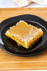 Organic honeycomb on wooden background. honey on the plate