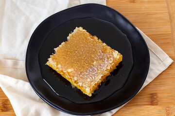 Organic honeycomb on wooden background. honey on the plate