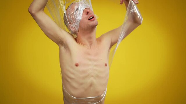 Medium shot of young male queer tearing film breaking free. Concept of fight for equal rights and sexual identity