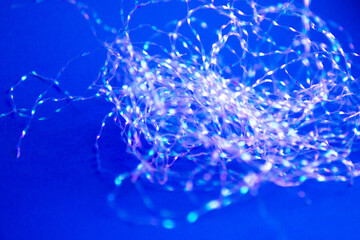 Christmas tree tinsel on a bright blue background. Top View of Xmas Decoration