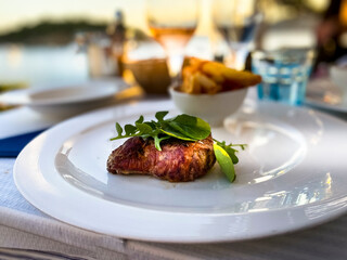 Spain, Mallorca, Port de Andratx, ghriled fillet steak in the evening sun by the sea