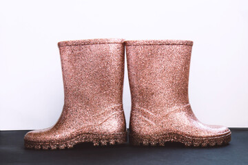 Shiny pink rubber boots on a black and white background