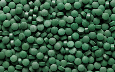 Spirulina pills background. Green tablets superfood.