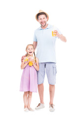 Vertical full length studio portrait of modern Caucasian man and girl wearing summer clothes standing together drinking fresh orange juice
