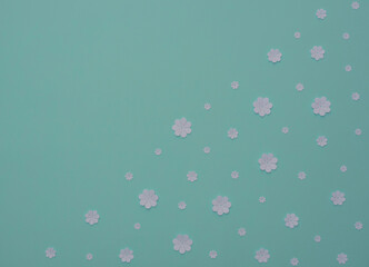 White paper flowers on blue background. Flat lay style with copy space. Paper art