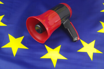 Advertising campaign in European Union concept. Megaphone on EU flag close up.