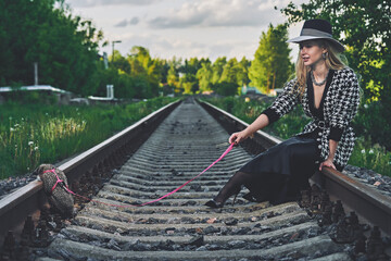 woman with hedgehog on leash walks the pet. retro style