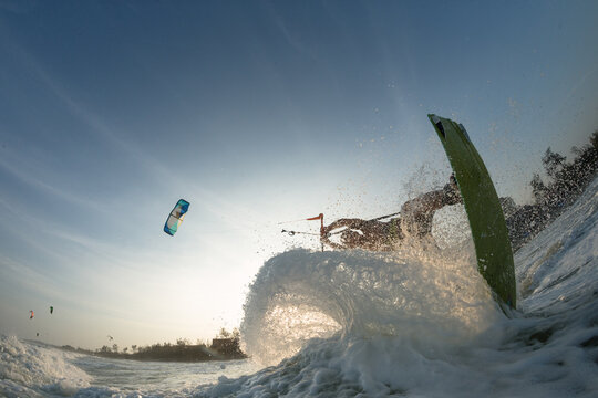 Kite surfer riding a kiteboard on the sea with splash