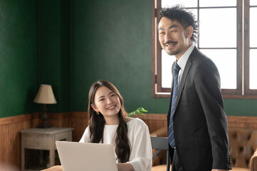 打合せを楽しそうにする上司と部下ポートレート　コピースペースあり1　カメラ目線