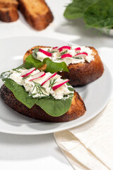 White plate with sandwiches made of cottage cheese and vegetables. Plate of sandwiches on white table. Concept of healthy eating.