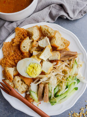 Indian rojak with fried dough shrimp fritters, tofu, egg, cuttlefish, shredded cucumber and turnip in thick spicy peanut gravy sauce / Popular Street Food / Made famous by Indian muslim in Malaysia
