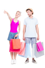Vertical full length studio portrait of handsome man and beautiful woman wearing summer outfits carrying shopping bags, white background
